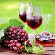 A table with two glasses of wine and grapes.
